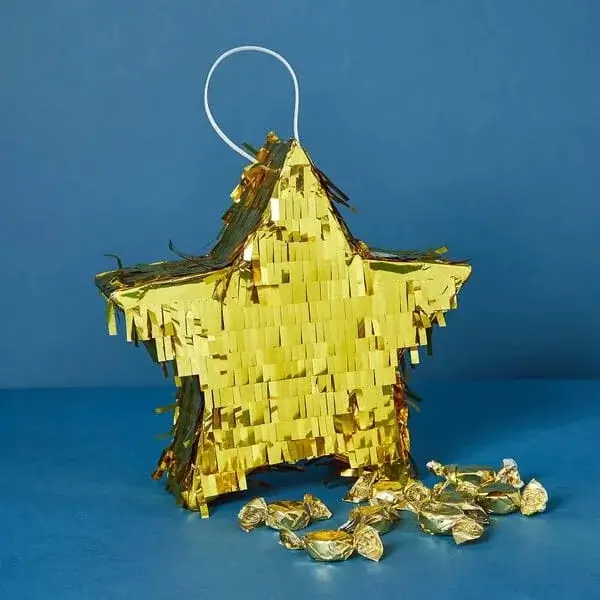 Gold star-shaped piñata filled with wrapped sweets against a blue background.
